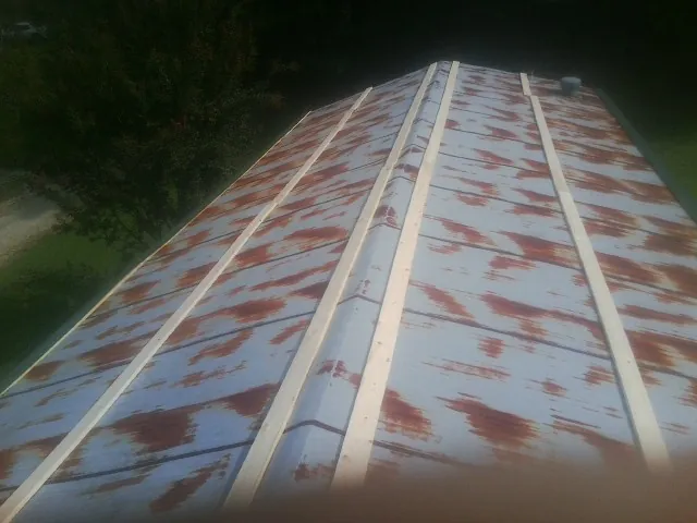 Rusted metal roof panels with new wood purlins before replacement — Storm Damage Roof Repair in Usaf Academy by Roofing Brothers