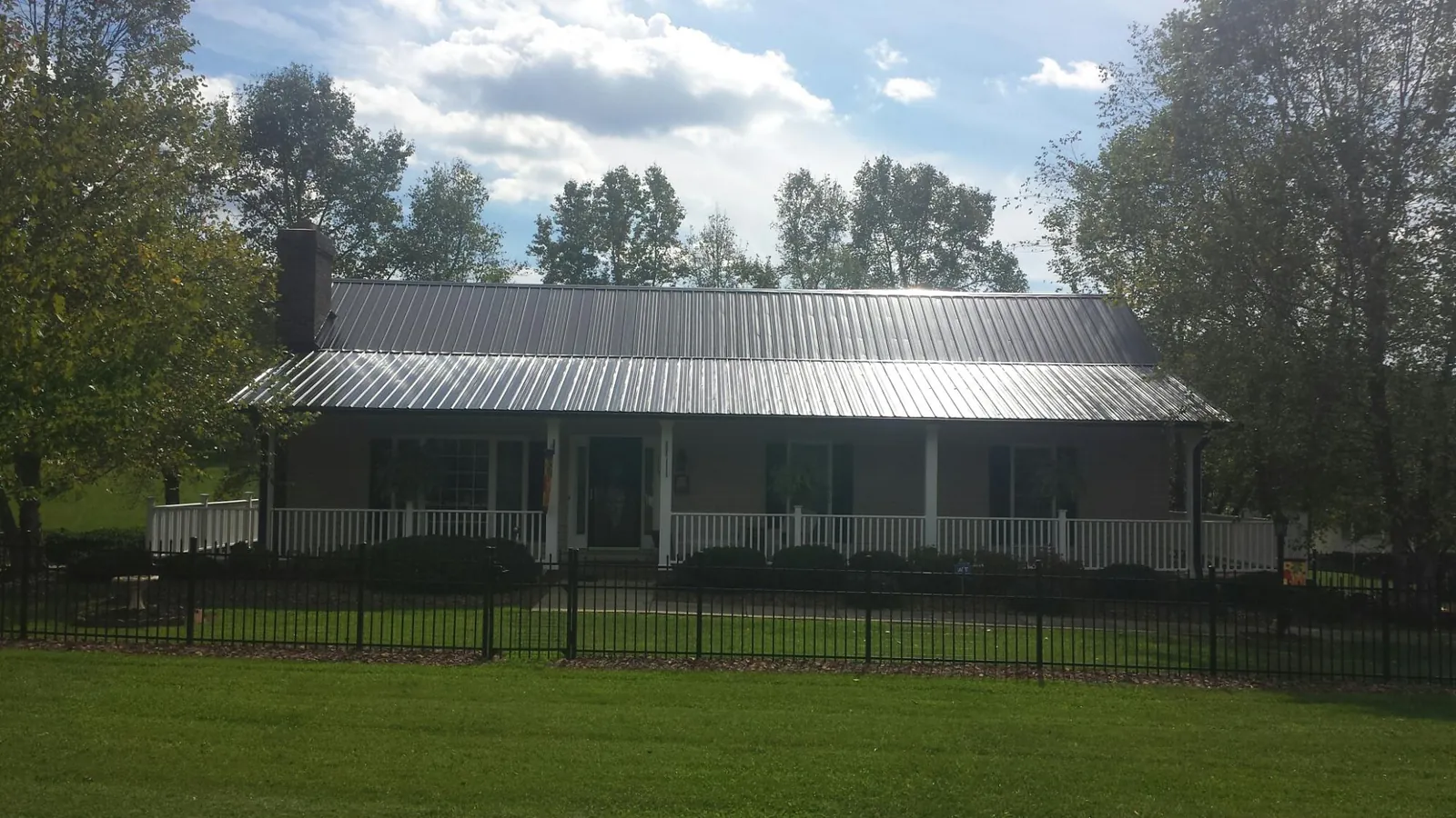 Gray metal roof on a brick ranch with a full width front porch — Gutter Guard Installation work by our crew in Usaf Academy