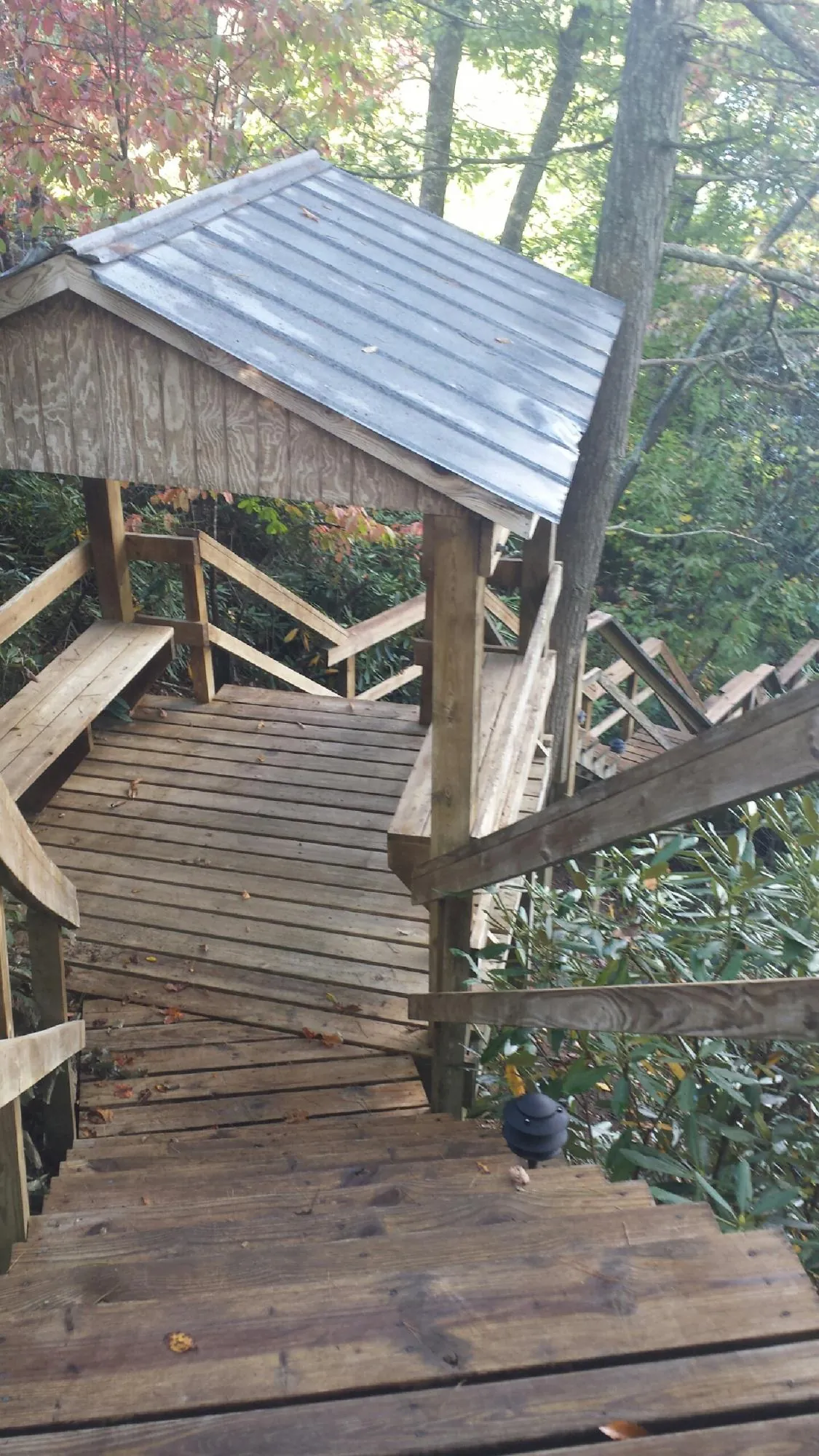 Metal roofed shelter over wooden steps on a wooded walkway — Skylight Repair & Installation work by our crew in Usaf Academy