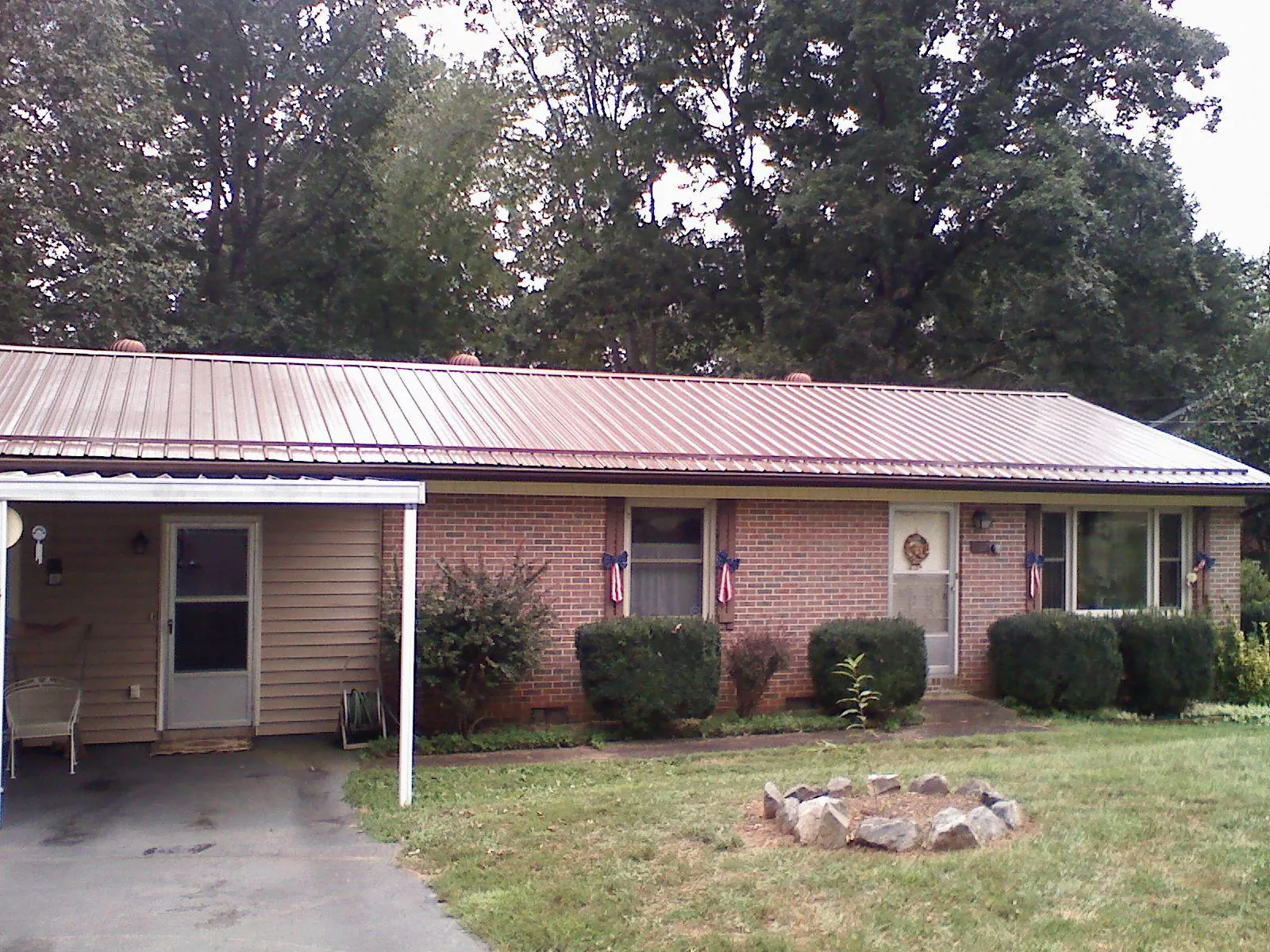 Bronze metal roof and carport on a brick ranch home — Roof Repair work by our crew in Usaf Academy