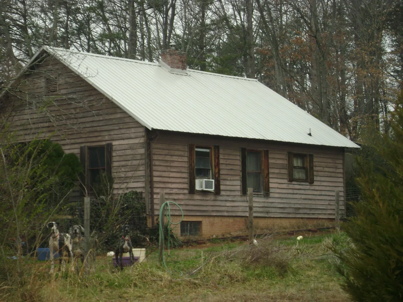 White metal roof on an old wood sided farmhouse, from a Metal Roof Installation job in Usaf Academy